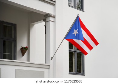 Puerto Rico Flag. Puerto Rican Flag Hanging On A Pole In Front Of The House. National Flag Waving On A Home Displaying On A Pole On A Front Door Of A Building. Flag Raised At A Full Staff.