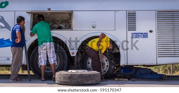 Puerto Suarez, Bolivia on August 21, 2015:\
Mechanic changing flat tire at bus\
breakdown