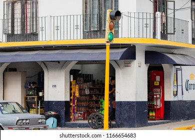 Puerto Vallarta Mexico 02/22/2017 Daytime Street Scene With Man Inside Corner Store With Wheel Chair Outside And Traffic Light.