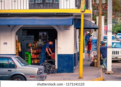 Puerto Vallarta Mexico 02/22/2017 Street View Of Mexican Man Inside Corner Store Playing Game With Pedestrians And Parked Cars In Zona Romantica.