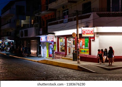 Puerto Vallarta Mexico 02/28/2017 Night Street Scene Of Corner Store With Pedestrians.