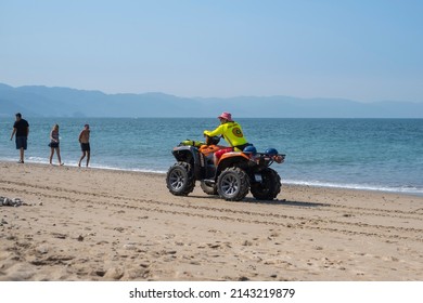 Puerto Vallarta Mexico Dec 2 2021: Beach Safe Guard Drive An ATV Along The Sandy Shoreline. Water Safety Concept.