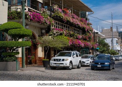 Puerto Vallarta Mexico Nov 27 2021: Building Covered With Blooming Colorful Flowers On A Local Street. Sunny Day, Blue Sky.