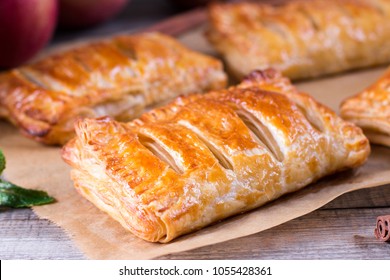 Puff pastry apple pastry turnovers for dessert on a wooden table - Shutterstock ID 1055428361