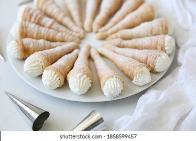 Puff pastry Cream Horns or Kremrole:  a crispy roll-shaped puff pastry filled  with whipped cream. a delicious easy homemade dessert. Top view, flat lay, white background, copy space.