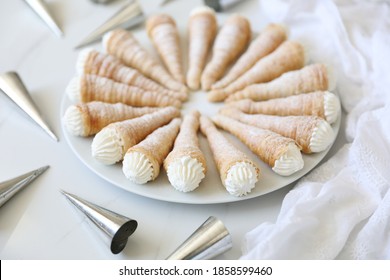 Puff pastry Cream Horns or Kremrole:  a crispy roll-shaped puff pastry filled  with whipped cream. a delicious easy homemade dessert. Top view, flat lay, white background, copy space.