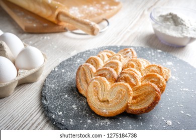 Puff pastry eyelet on slate Board, sprinkled with powdered sugar or flour - Powered by Shutterstock