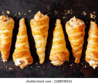 Puff pastry horns filled with Italian meringue, Schaumrollen o Cream Horns on dark background, copy space, top view, flatlay, no people.