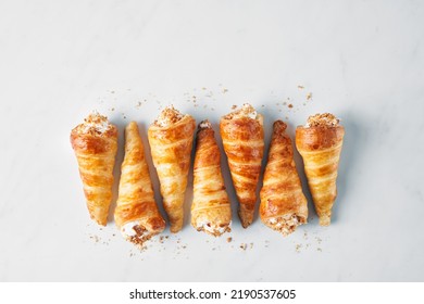 Puff pastry horns filled with Italian meringue, Schaumrollen o Cream Horns on white background, copy space, top view, flatlay, no people.