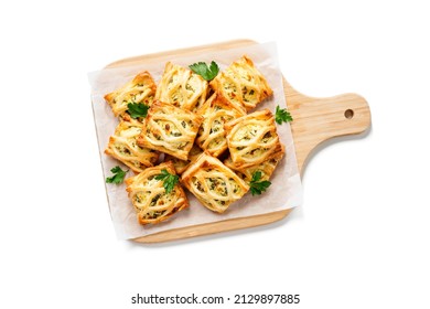 Puff pastry squares filled with feta cheese and spinach isolated on white background, top view