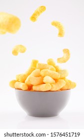 puffed corn chips in gray bowl and sprinkled isolated on white background