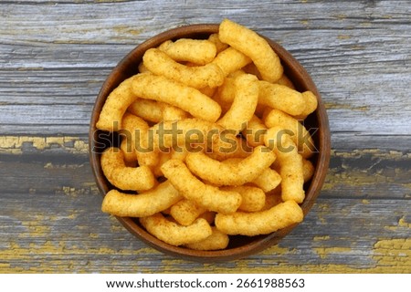 Puffed corn peanuts snacks isolated on wooden background.