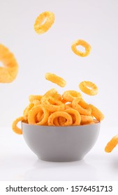 puffed corn rings chips in gray bowl and sprinkled isolated on white background