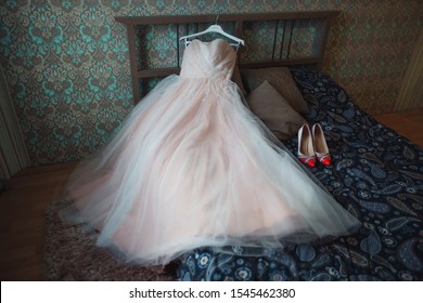 Puffy Wedding Dress On The Bed With Shoes