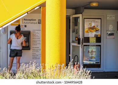 Puilboreau, France - August 7, 2016 : Rear View Of Young Woman Making Automatic Hotel Reservation At Registration Kiosk In Hotel At Puilboreau, France.