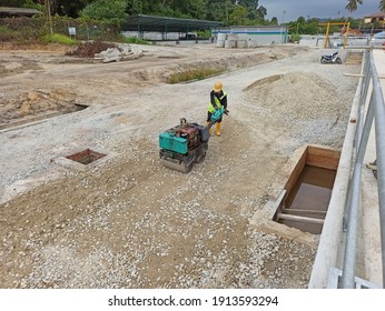 Pulau Pangkor, Perak, Malaysia. 8 January 2021. Worker compacting subbase for premix road in construction site. 