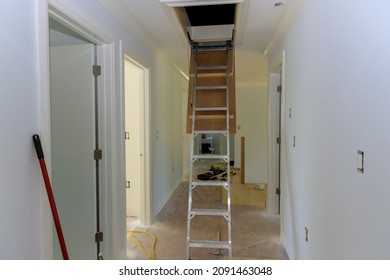 Pull Down Folding Attic Ladder Stairs In Small Hallway On Under Construction New Home