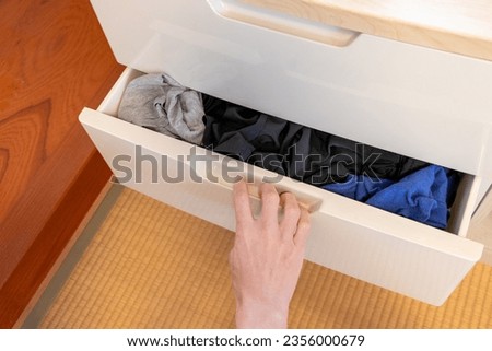 pull out a drawer with clothes