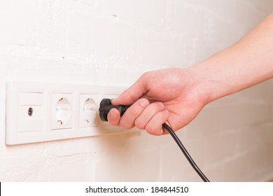 Pull The Plug Concept With Man Pulling Black Cord And Plug. Close Up