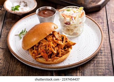 Pulled Bbq Chicken Sandwich On A Brioche Bun Served With Cole Slaw And Bbq Sauce