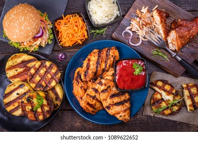 Pulled chicken, Korean carrot salad, cabbage salad, grilled chicken breast and grilled cheese on a wooden table - Shutterstock ID 1089622652