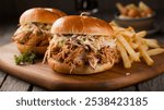 Pulled Chicken Sandwich with Coleslaw ? Delicious pulled chicken sandwich with tangy coleslaw and crispy fries, set on a rustic wooden