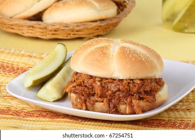 Pulled Pork Barbecue Sandwich With Pickles On A Plate