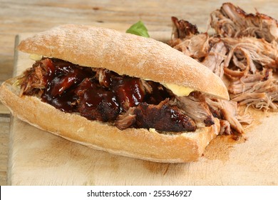   pulled pork with barbecue sauce on a crusty bread roll                             