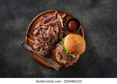 Pulled pork burger. Burger with pork meat on a wooden board. - Shutterstock ID 2205482123