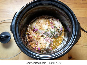 Pulled Pork Meat Cooking In Crock Pot Or Slow Cooker, With A Wooden Background. Viewed From Above.