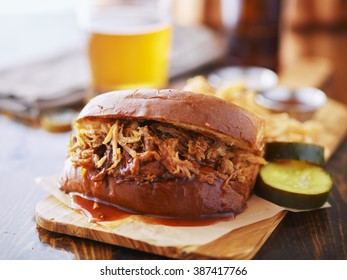 Pulled Pork Sandwich On Wooden Tray With Pickles And Beer