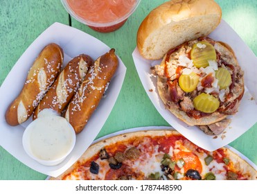 Pulled Pork Sandwich, Preztel Sticks And Chili Dog With Cocktail On Tiki Bar Green Table