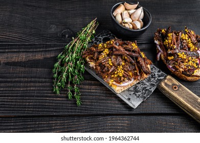 Pulled Pork Sandwich With Smoked Pork Meat On A Meat Cleaver. Black Wooden Background. Top View. Copy Space