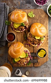 Pulled pork sandwiches with BBQ sauce, cabbage and pickles overhead shot