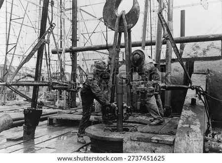 Pulling clamp of elevator in place to being up section of drill pipe, oil well, Kilgore, Texas by Russell Lee. Vintage photography by Russell Lee. Vintage America in photo by Russell Lee.