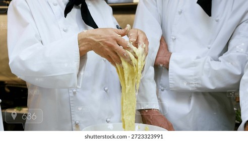 Pulling left chef's hands stretching dough at commercial kitchen counter, with mixing bowl, jackets. Culinary, bakery, collaboration, batter, stainless, industrial, workstation