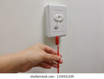Pulling red emergency call switch for calling nurse to rescue in patient shower room.  