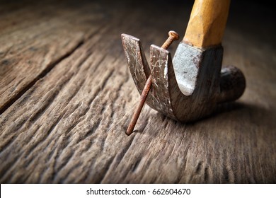 Pulling rusty nail out of old wood with hammer, Selective focus