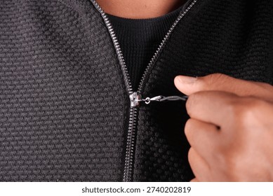 Tirando de una cremallera en una chaqueta negra