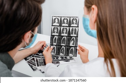 Pulmonologist Wearing In Protective Mask Showing Man Patient A CT Scan Of His Lungs. Pneumonia, Coronavirus, Lung Disease