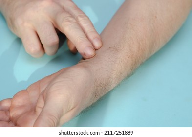 Pulse Check. Middle-aged Man With His Finger On His Wrist. Close-up. Inside The Room. Selective Focus.