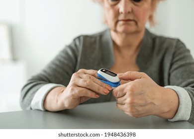 Pulse Oxymeter On A Woman Finger Hand On A Wooden Table. Top View.