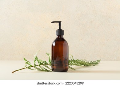 Pump amber glass bottle on beige background. Soap liquid, shampoo or shower gel packaging design. Beauty blogging, salon treatment concept, minimalism brand packaging mock up