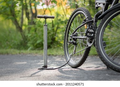 A pump and a bicycle. Bicycle repair in the forest. Close up. - Powered by Shutterstock