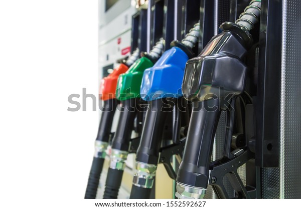 Pump nozzles at\
the gas station isolated on white background. Shallow depth of\
field with focus on nozzle\
red