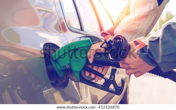 Pumping gas. Hand holding\
fuel nozzle.