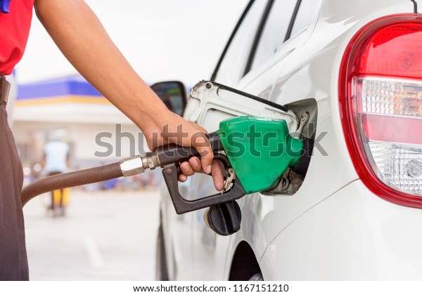 Pumping gas at gas pump. Closeup of man pumping\
gasoline fuel in car at gas\
station