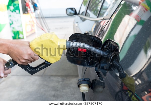 Pumping gas at gas pump. Closeup of man pumping\
gasoline fuel in car at gas\
station