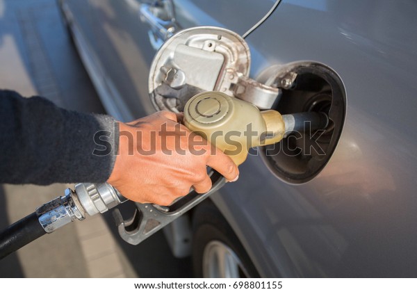 Pumping gas at gas pump. Closeup of man pumping\
gasoline fuel in car at gas\
station.