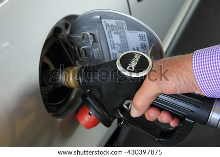 Pumping gas at a self service gas station (Diesel is a type of fuel)